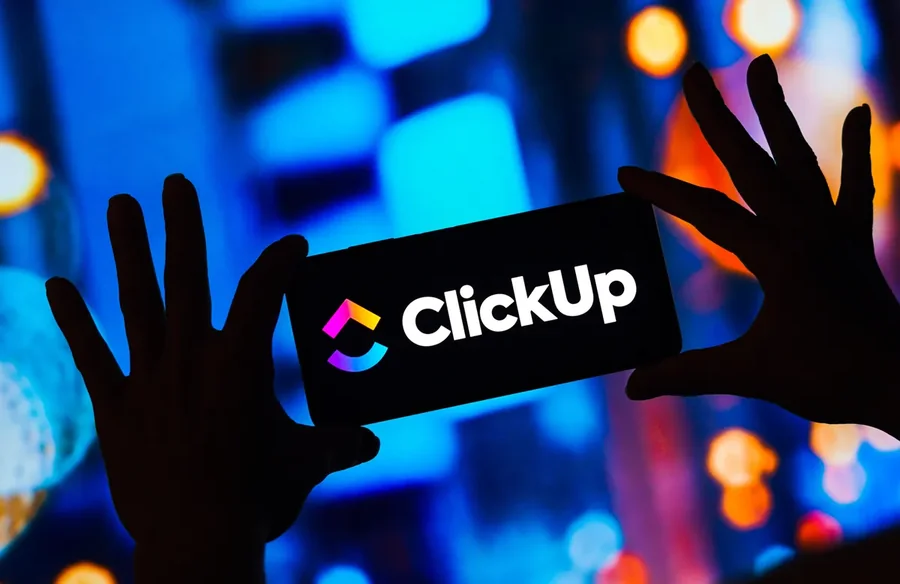 Painel com a marca ClickUp acesa e silhuetas em primeiro plano